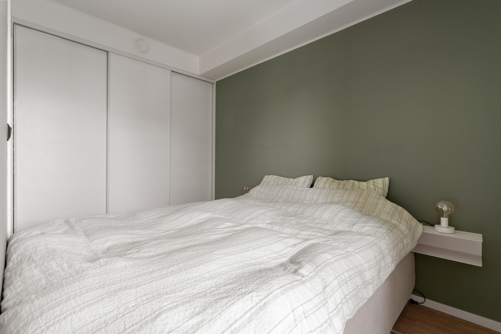 Praktisk skyvedørsgarderobe som utnytter hele veggen.