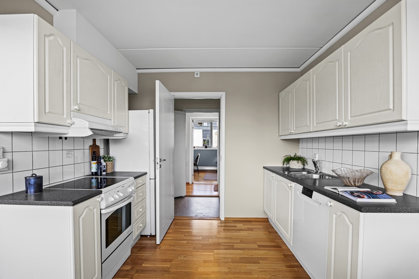 Kjøkkeninnredning med profilerte fronter, benkeplate i laminat og nedfelt kum i rustfritt stål. Galleribilde