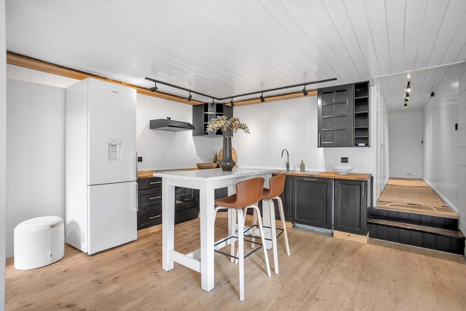 Kjøkkenet i hybelen har en praktisk utforming med gode arbeidsflater, spiseplass ved kjøkkenøy og åpen løsning mot stuen. Galleribilde