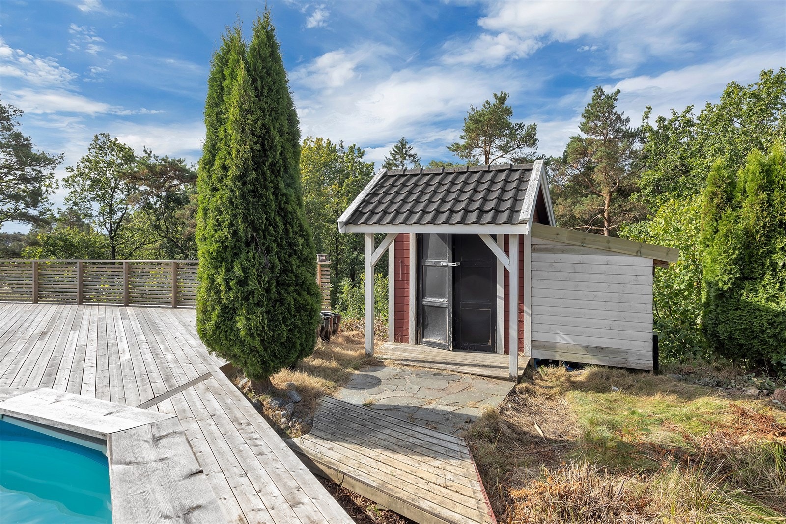 Uteboden gir praktisk plass til oppbevaring av hageredskaper, puter og annet utstyr. Deler av boden er plassert utenfor eiendomsgrensen og inn på naboeiendommen. Galleribilde