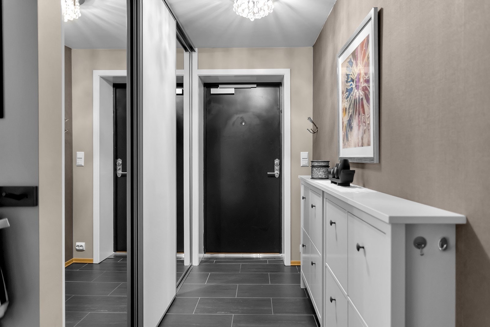 Lys og innbydende entré med flislagt gulv og praktisk skyvedørsgarderobe. Galleribilde