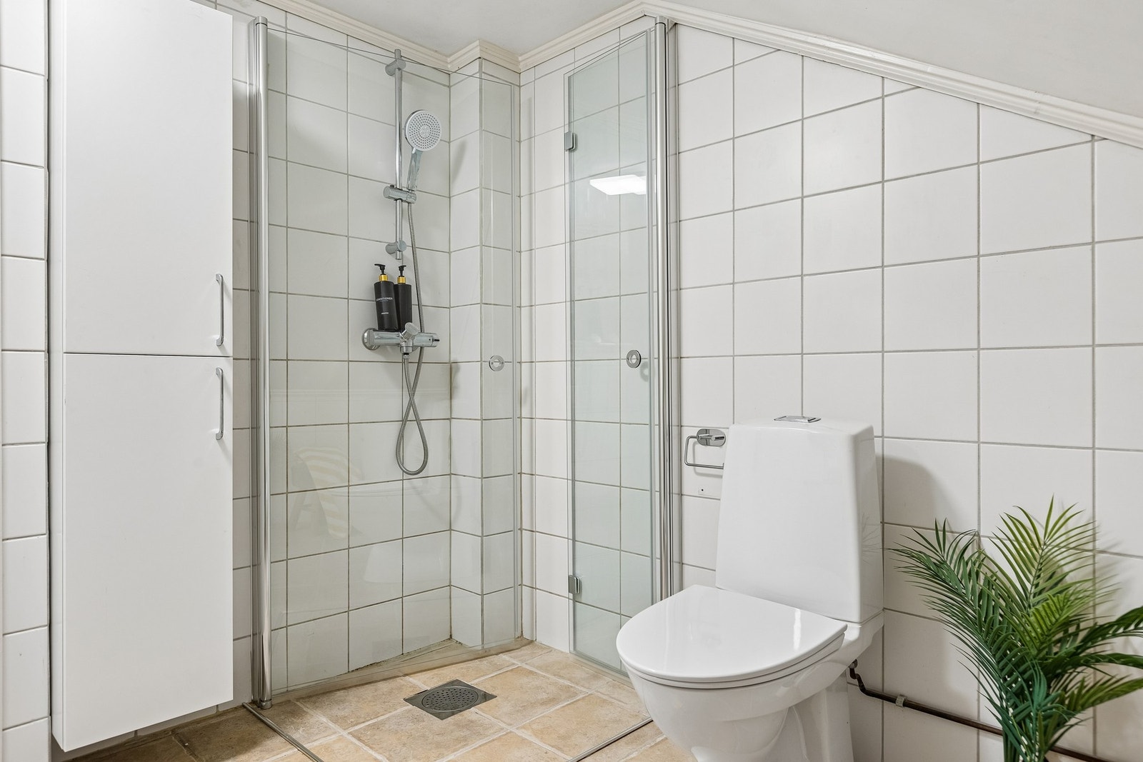 Badet er lyst og innbydende, med romslig dusjhjørne. Galleribilde