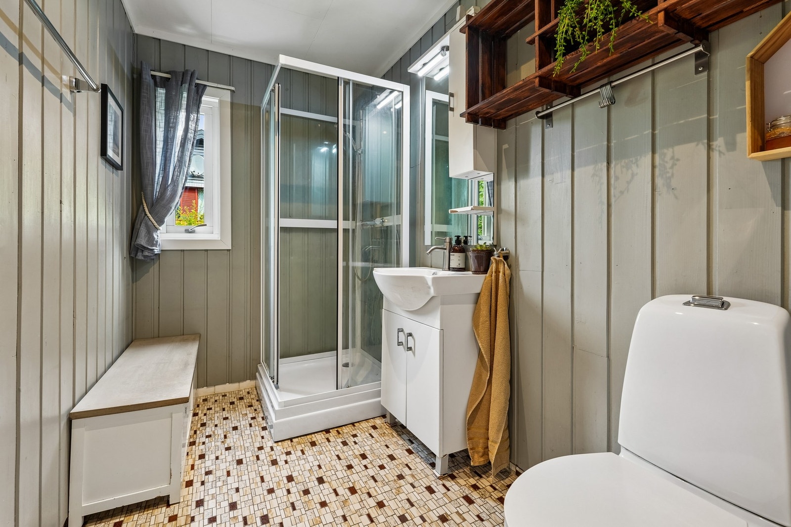 Badet i hovedetasjen er innredet med gulvmontert toalett, servantskap og dusjkabinett. Galleribilde
