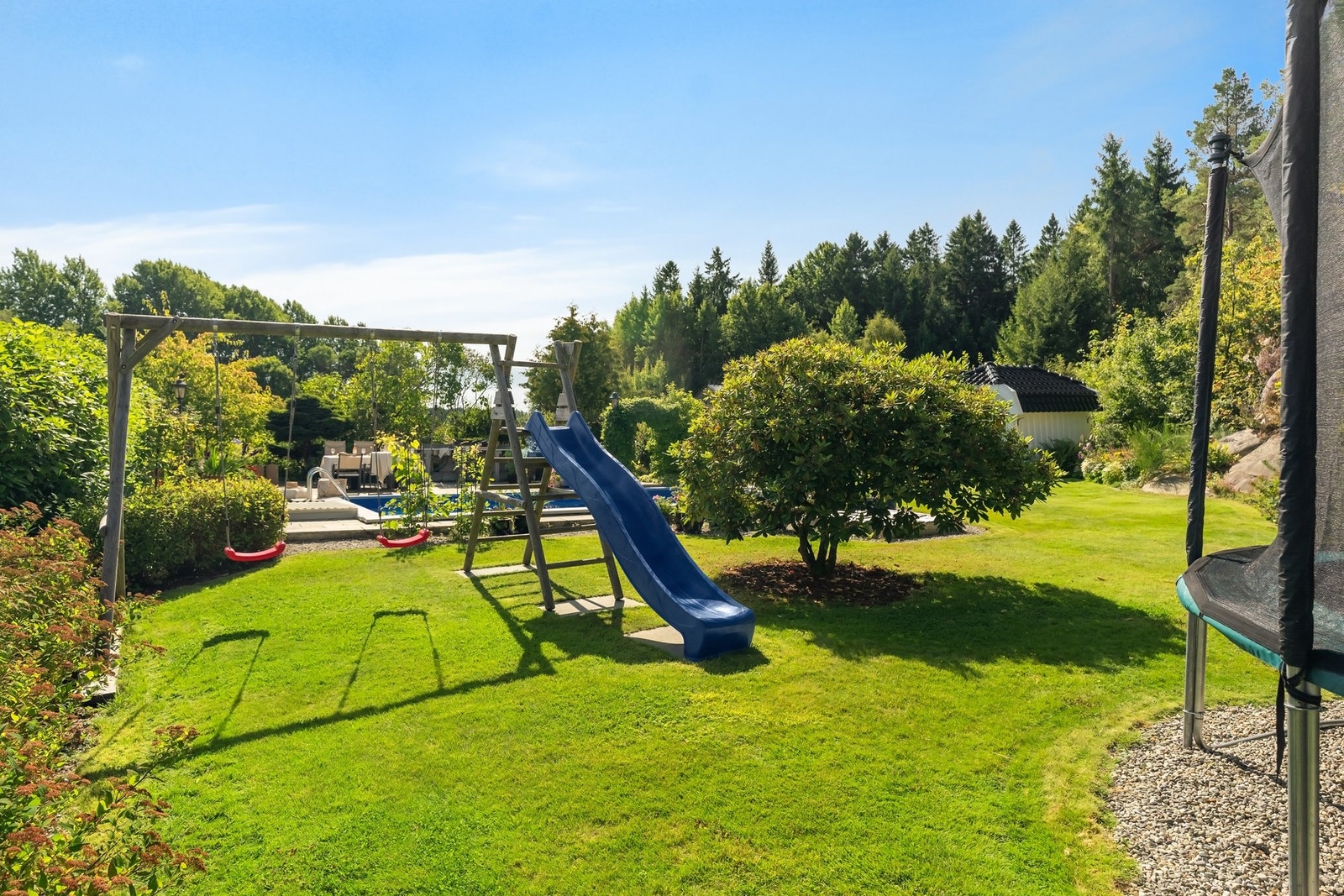 Eget lekeområde på en lun plass i hagen. Perfekt tilpasset de yngre med både trampoline, huskestativ, akesklie og sandkasse. Galleribilde