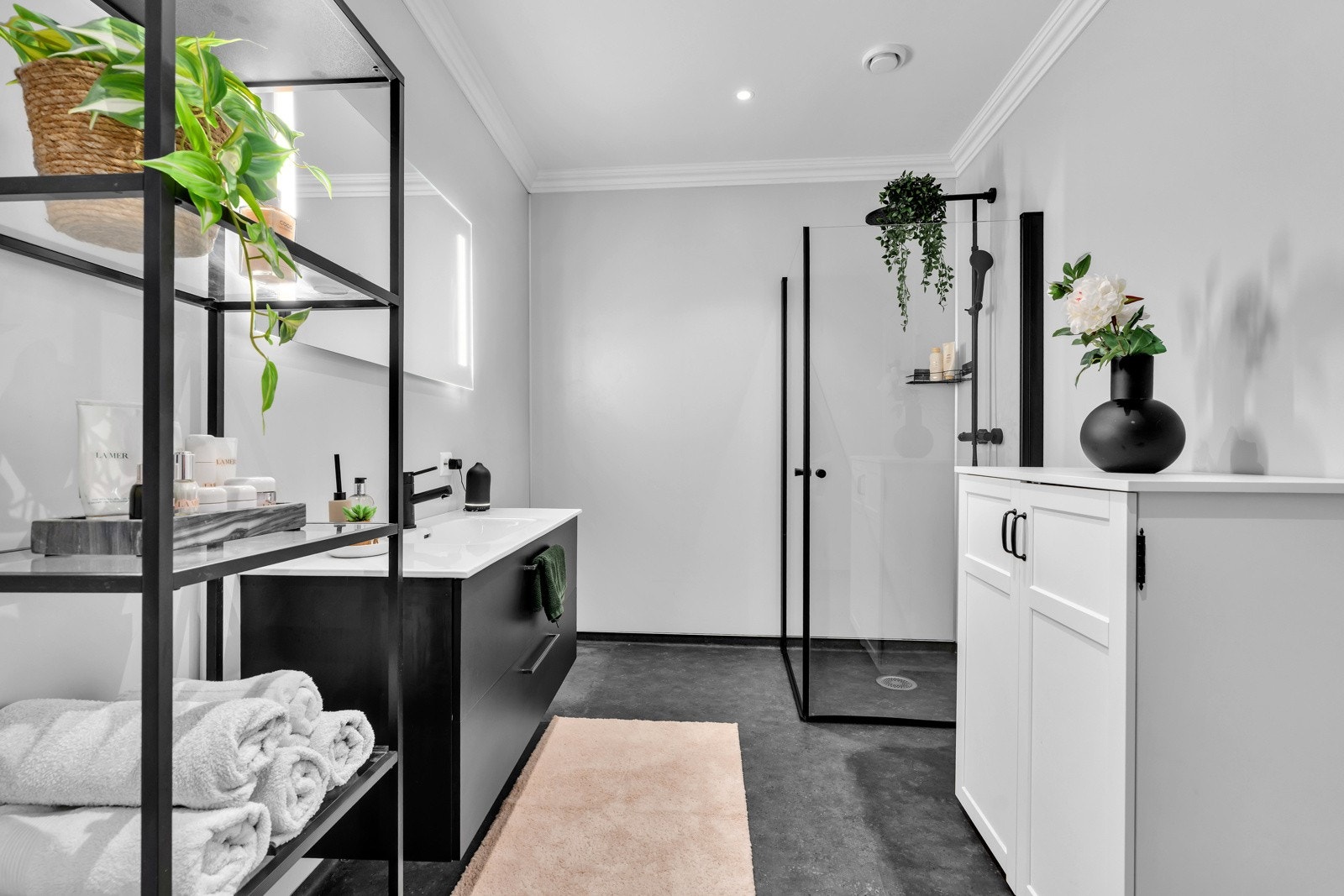 Badet har stilren baderomsinnredning fra Foss bad og har sorte detaljer på armatur og dusj. Galleribilde