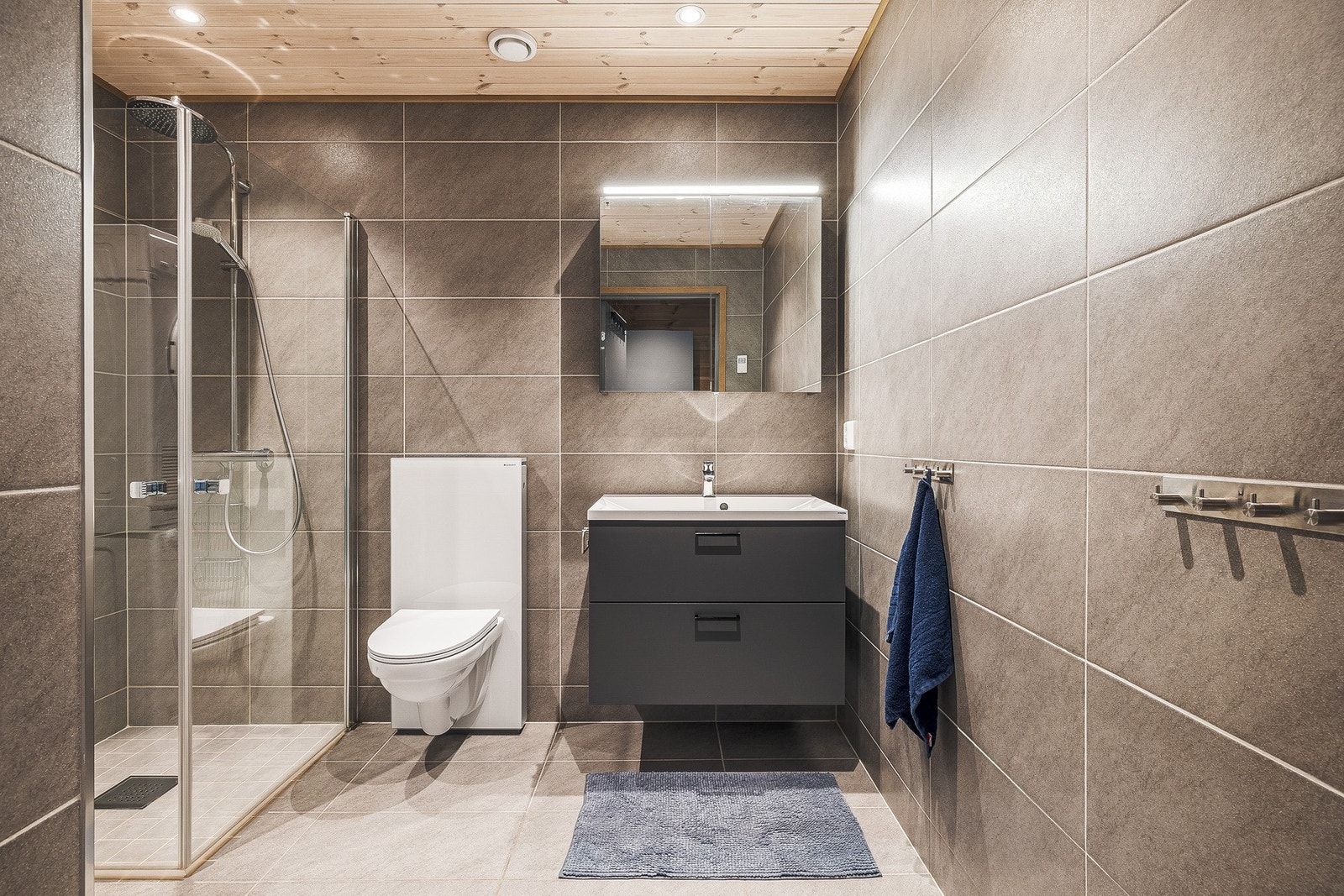 Badet er flislagt på gulv og vegger, og har varmekabler i gulvet Galleribilde