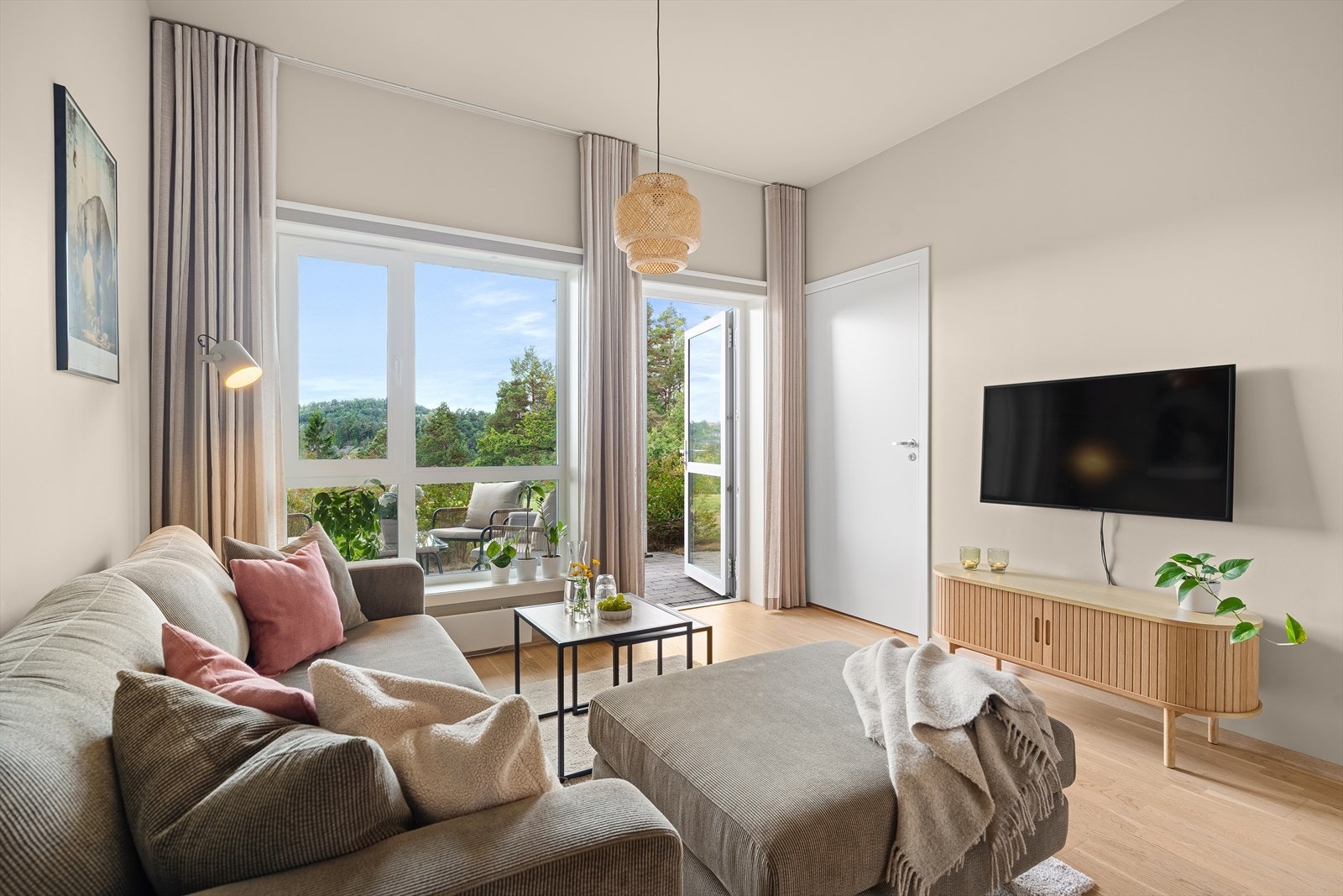 I stuen er det lyst og trivelig med store vindusflater som slipper inn rikelig med naturlig dagslys. Det er spesialbestilt høye gardiner som forlenger takhøyden visuelt. Galleribilde
