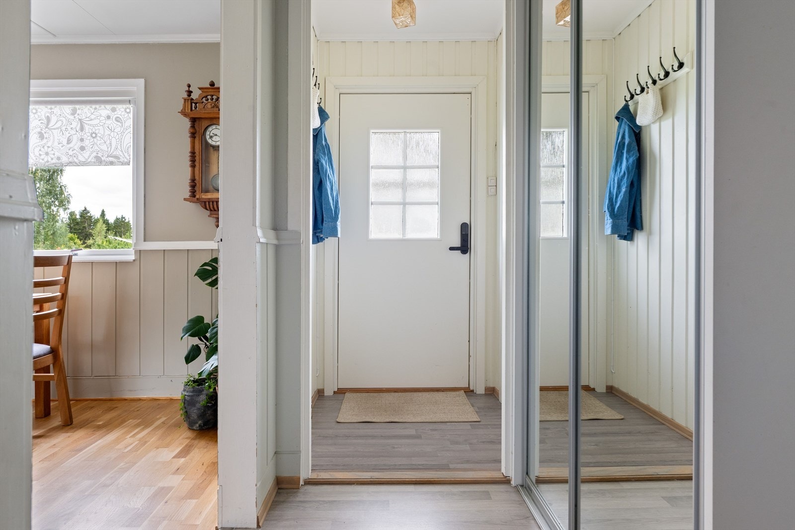 Lyst vindfang med avhengingsplass, gang med skyvedørsgarderobe. Galleribilde