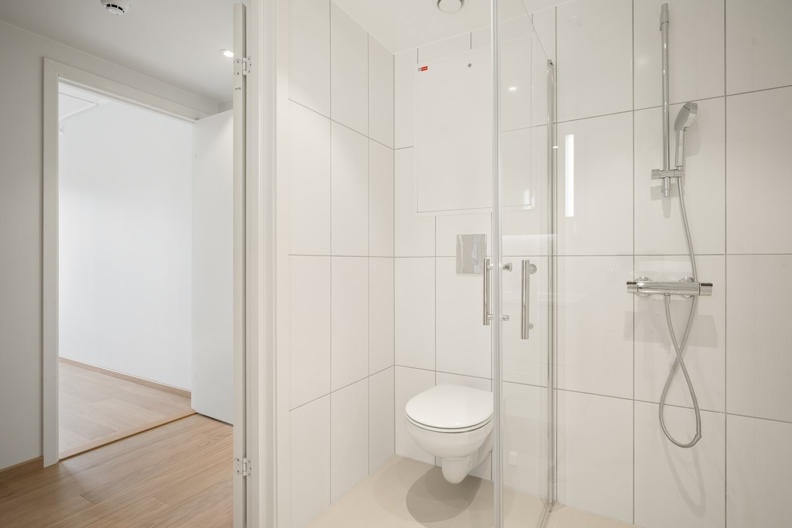Bad/vaskerom med fliser i store formater og downlights Galleribilde
