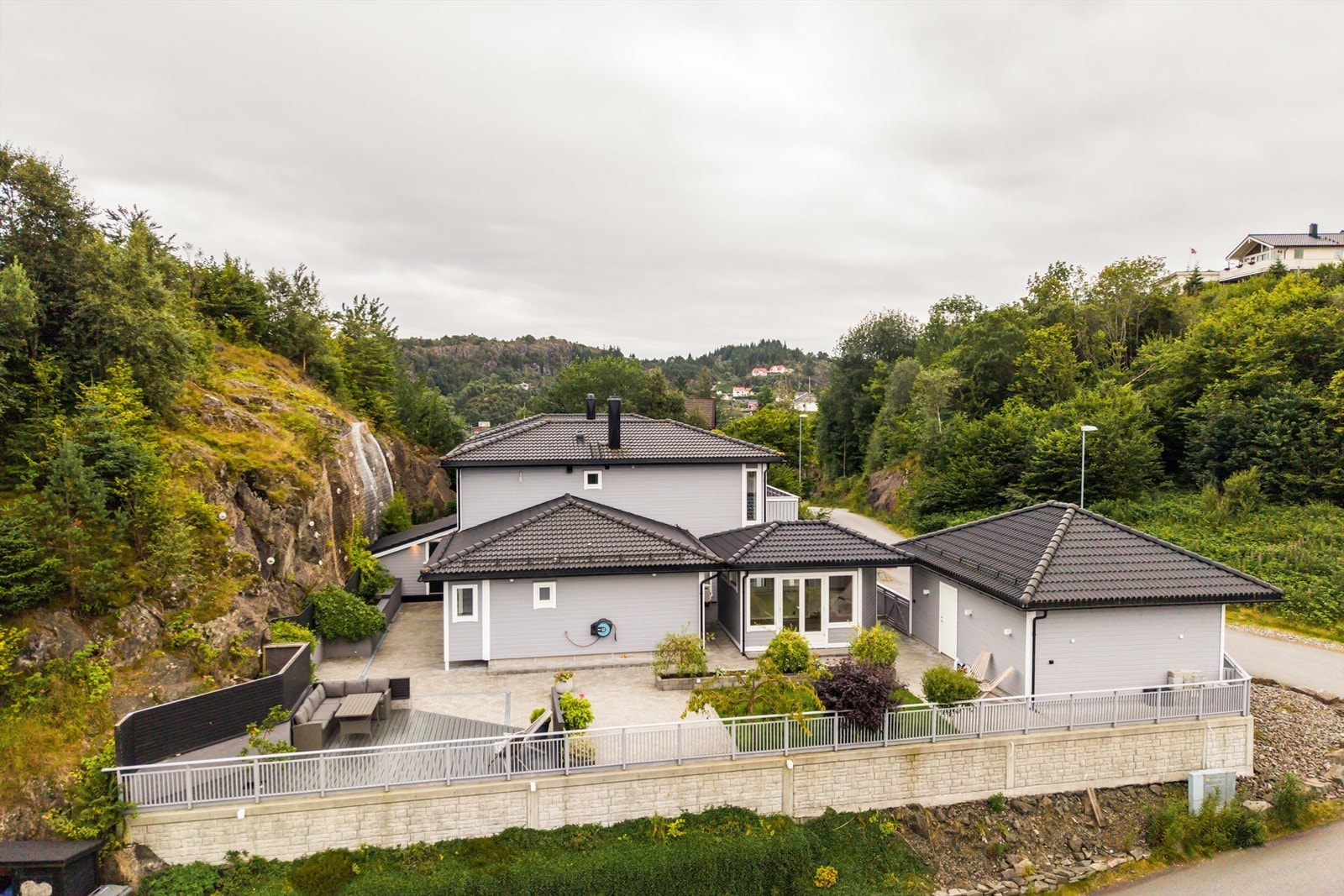 Hele eiendommen er inngjerdet og pent rammet inn av forstøtningsmurer i betong. Galleribilde