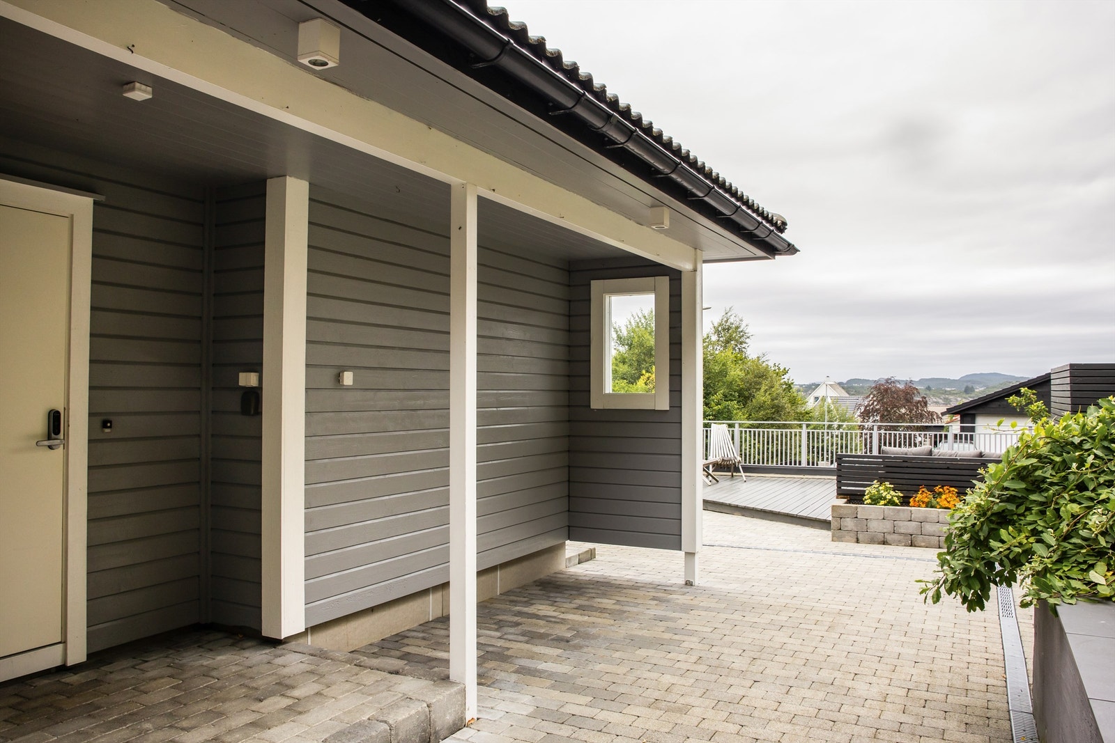Fra det overbygde inngangspartiet ser man ut over uteområdet. Galleribilde