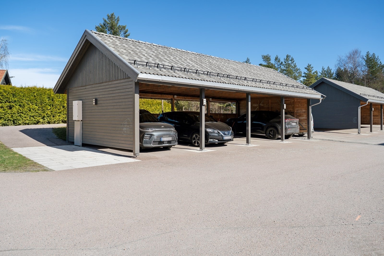 Du disponerer en parkeringsplass i carport, der det er montert elbillader. Galleribilde