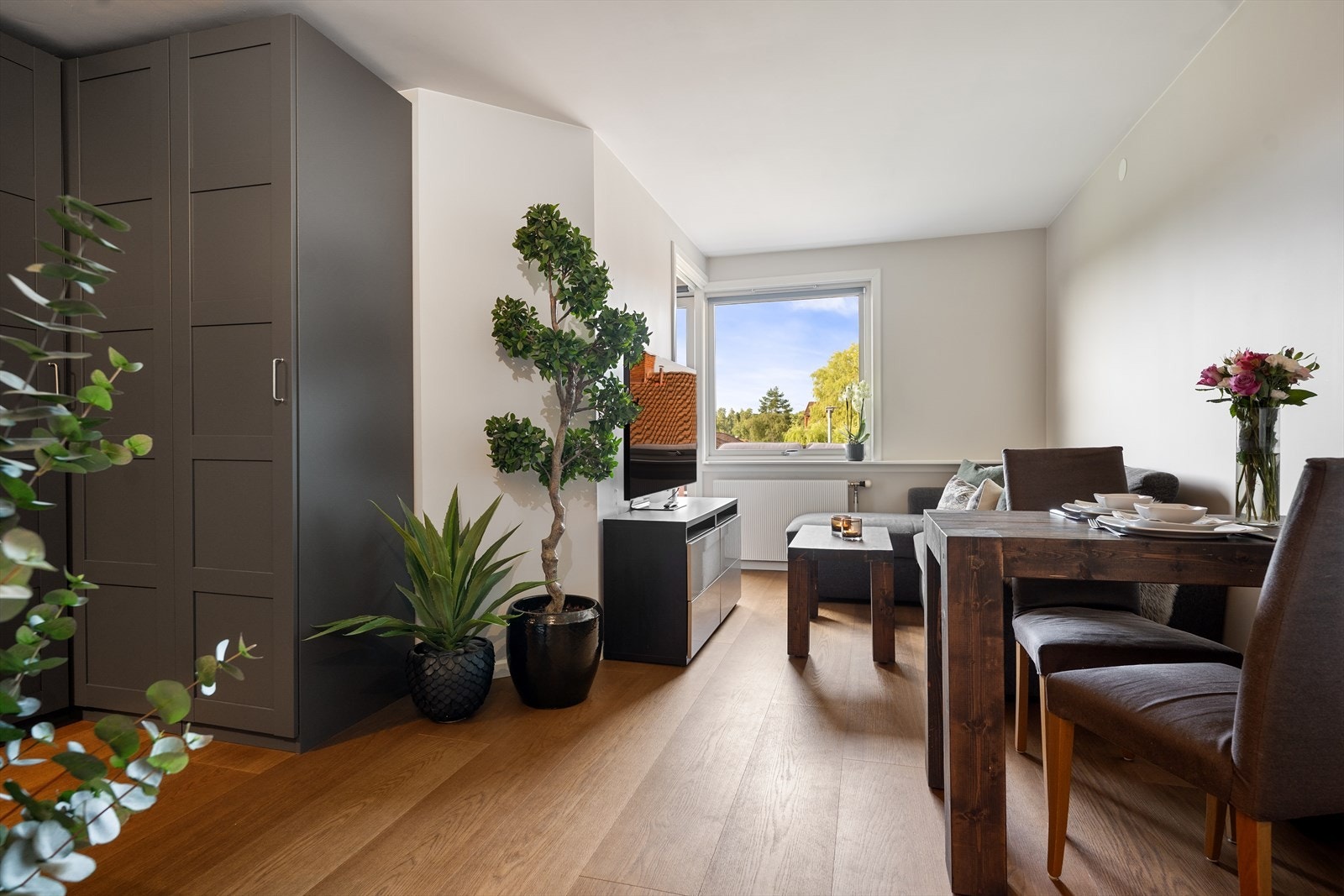 Leiligheten har åpen stue og kjøkkendel hvor det er plass til både sofa, tv-møblement og et lite spisebord. Galleribilde