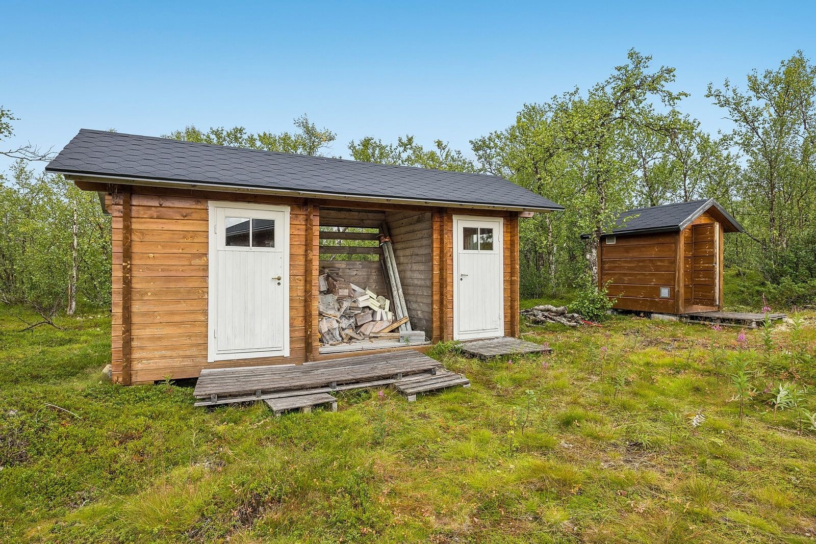 Frittstående utebod og utedo. Det er ca. 3 m² overbygd areal egnet for vedoppbevaring.