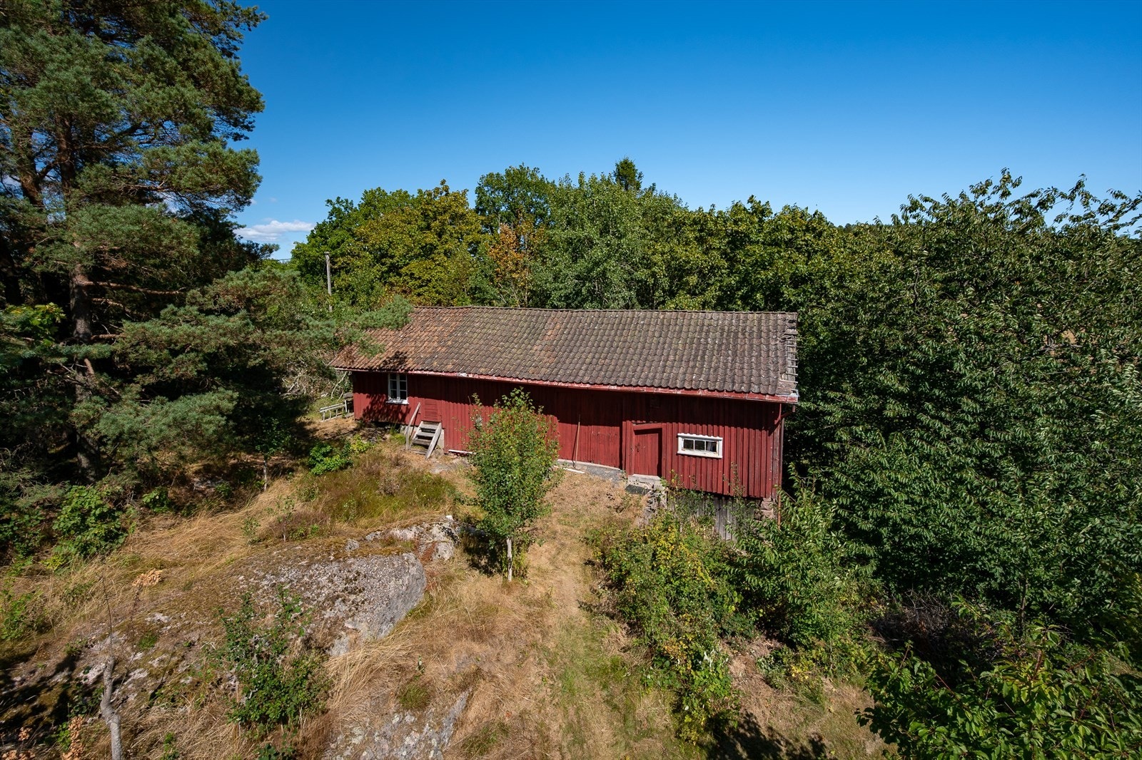 Småbruk bestående med enebolig og uthus beliggende 13 mål tomt Galleribilde