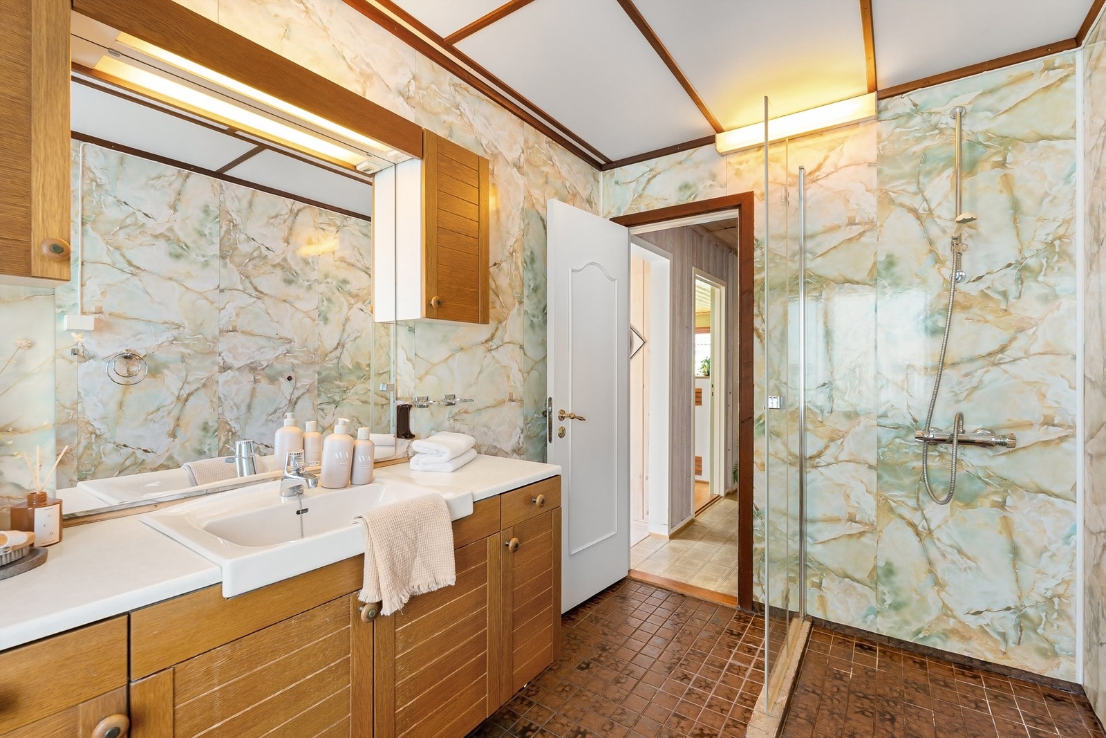 Badet er innredet med dusjhjørne med glassdør. Galleribilde