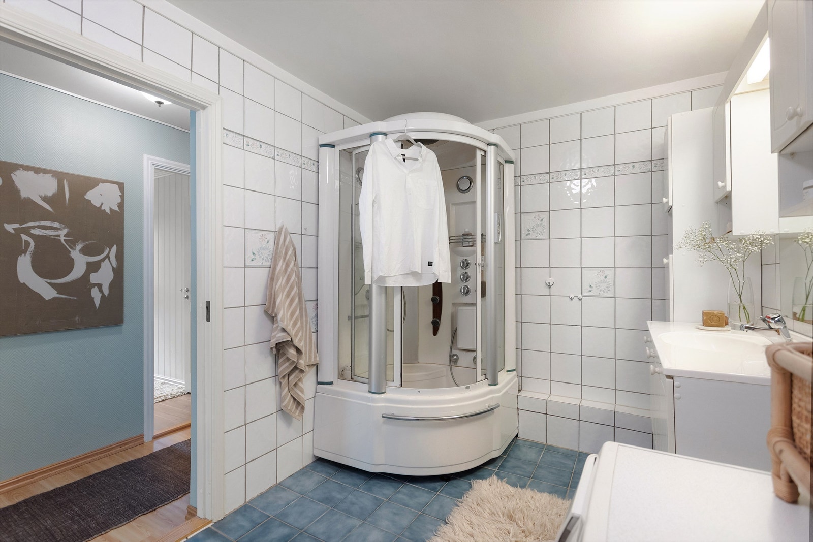 Flislagt bad med dusjkabinett og praktisk opplegg for vaskemaskin. Galleribilde