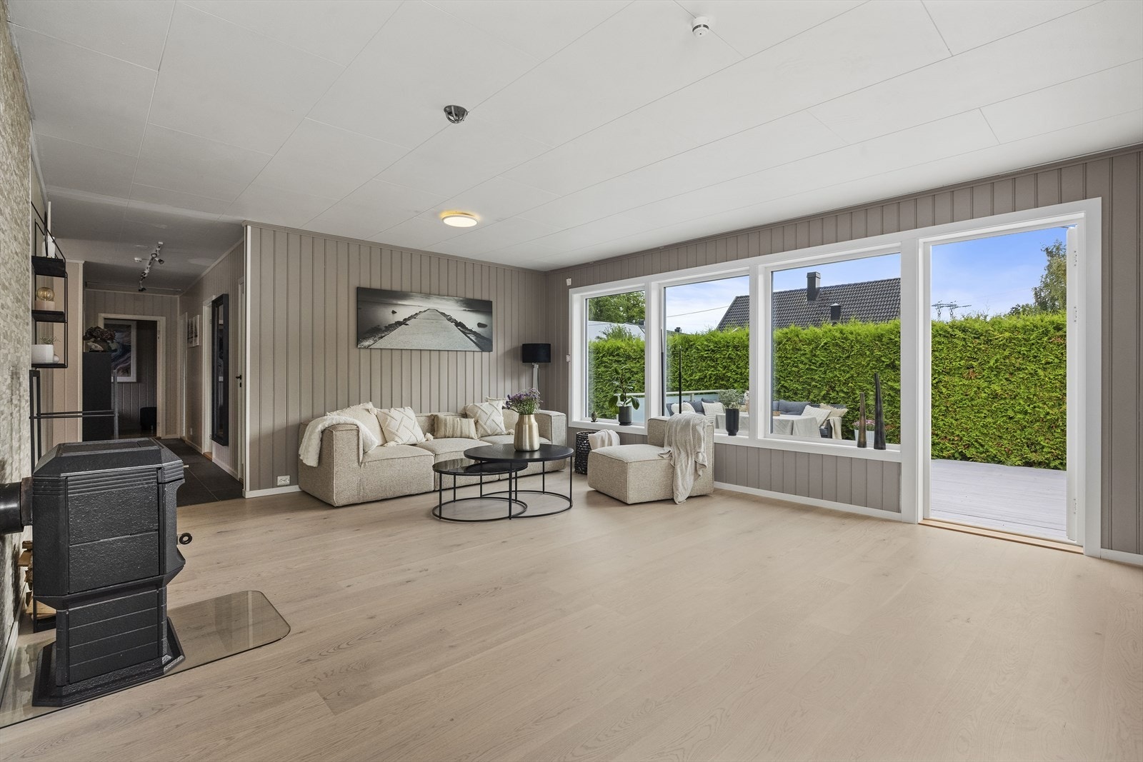 De store vindusflatene som vender ut mot den sørvestvendte terrassen slipper inn rikelig med naturlig dagslys og gir rommet en lun og god atmosfære. Galleribilde
