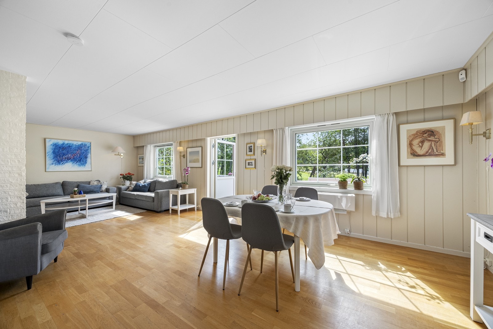 Store vindusflater gir godt lysinnslipp i rommet. Dør ut til terrasse. God plass til sofagruppe og spisebord. Galleribilde