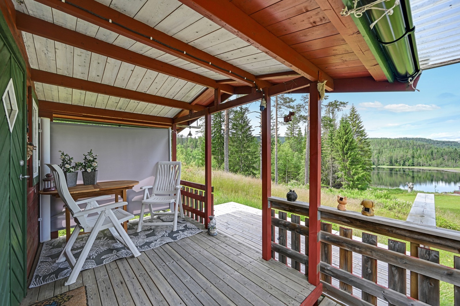 Den overbygde verandaen blir en naturlig forlengelse av hytta, med hyggelig sitteplass og flott utsyn mot vannet og omgivelsene. Galleribilde