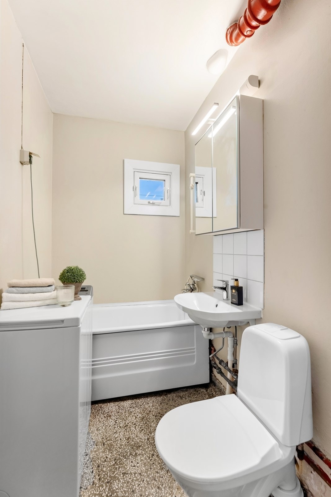 Badet er utstyrt med badekar og har vindu som gir naturlig ventilasjon. Galleribilde