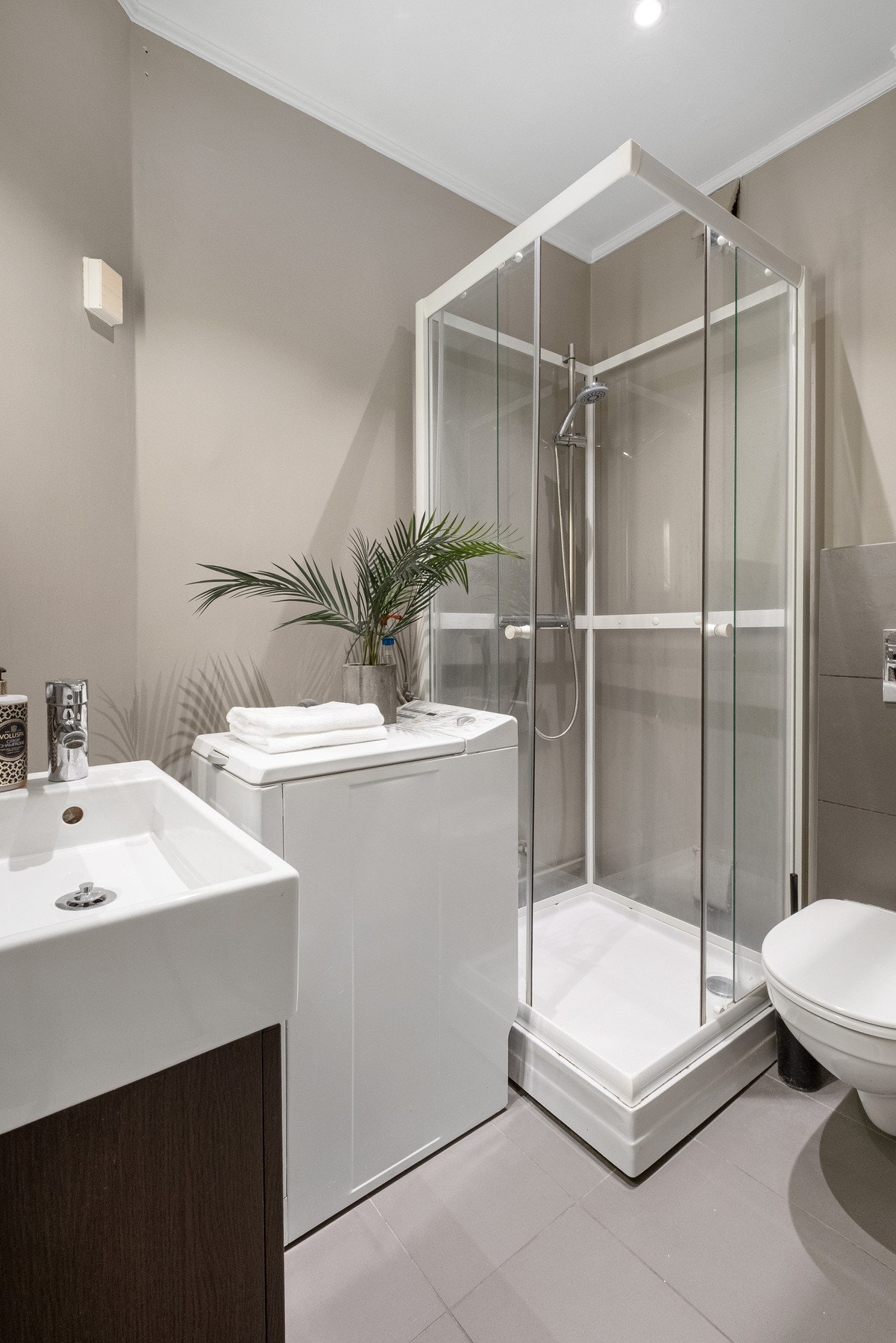 Badet har fint flislagt gulv med varmekabler og opplegg for vaskemaskin Galleribilde