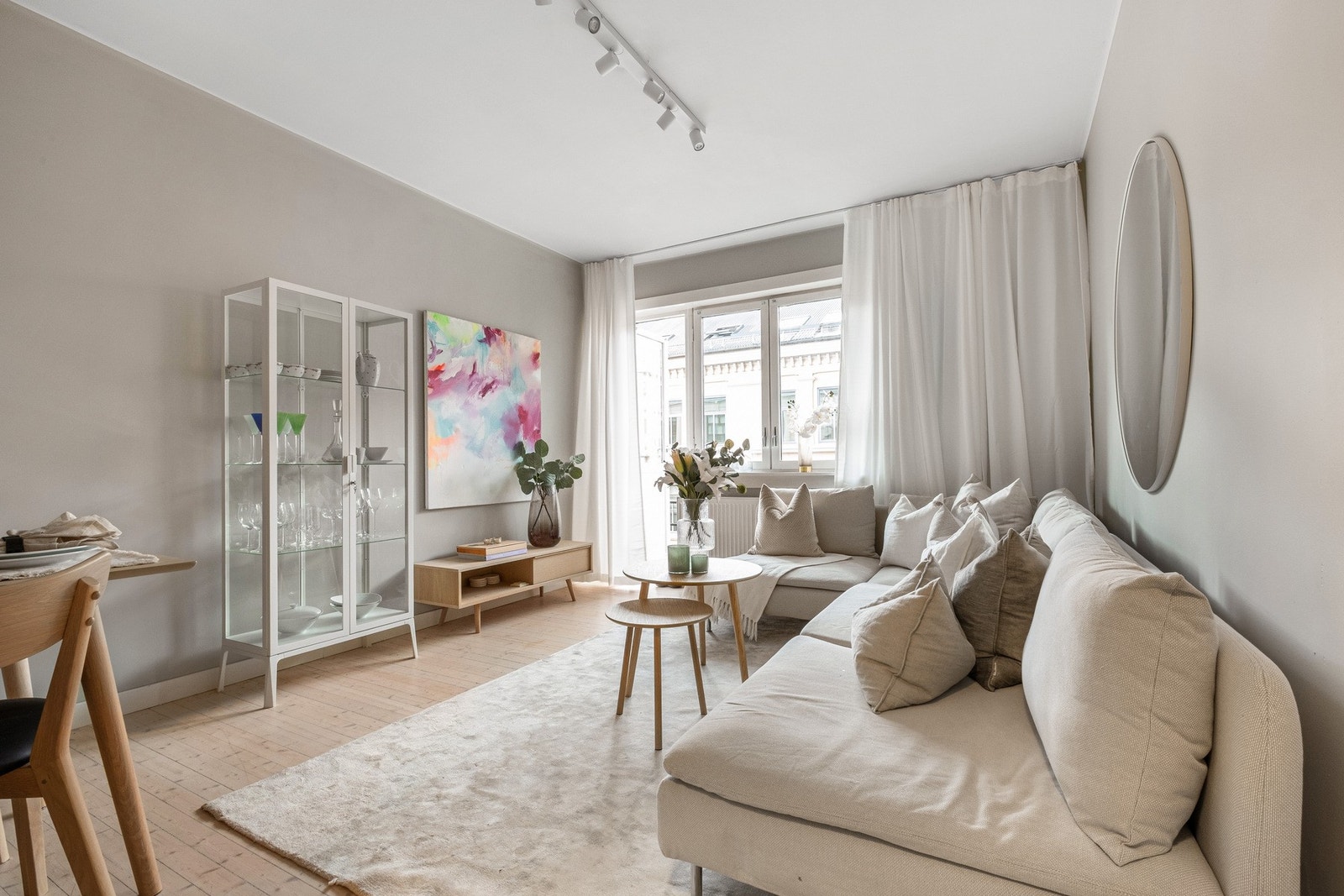 Stuen i leiligheten er romslig og flott opplyst med store vindusflater som gir rikelig med naturlig lys. I enden av rommet er det utgang til en brannbalkong Galleribilde