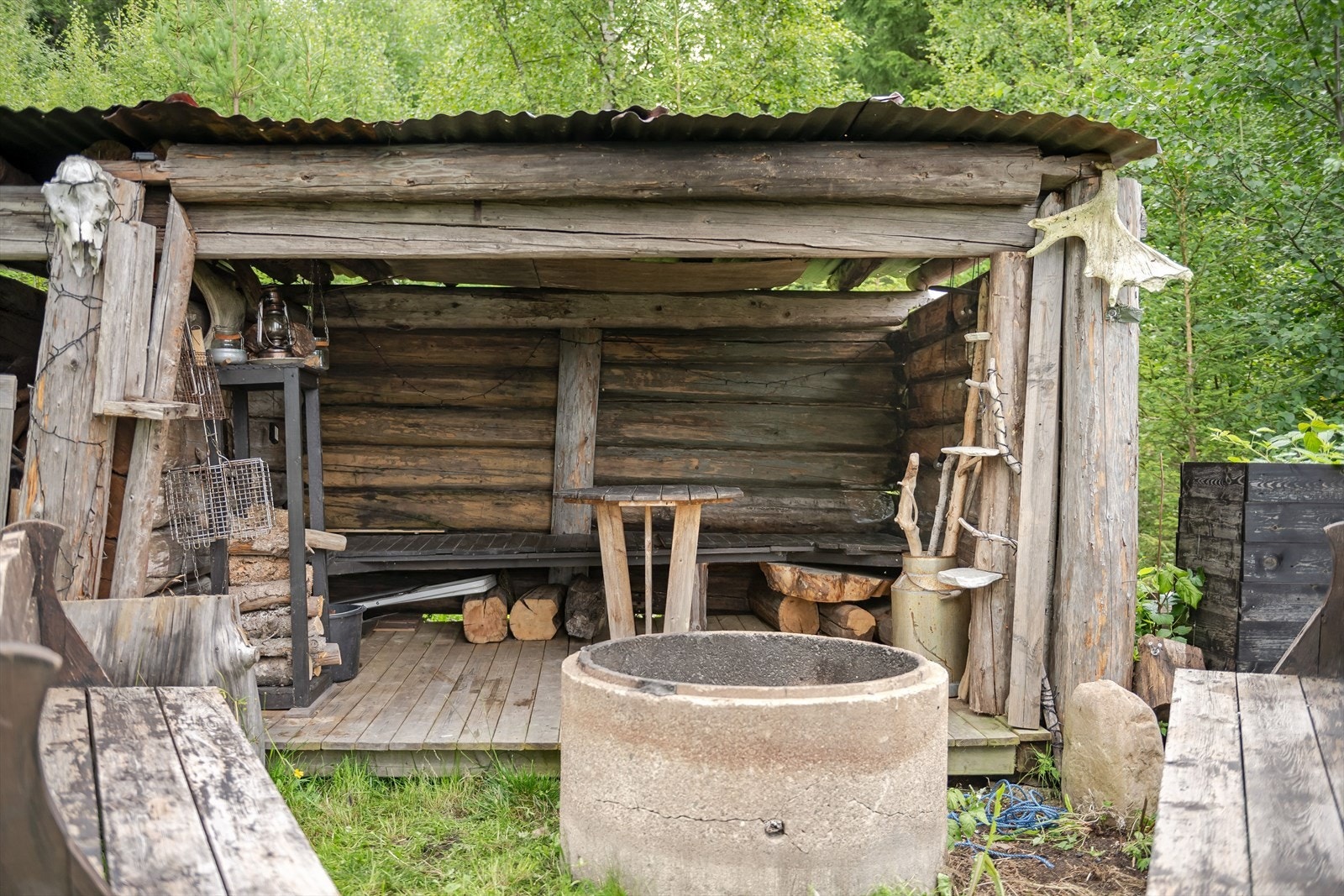 Gulvflater med terrassebord, yttervegger av laftet tømmer og tak er tekket med bølgeblikkplater. Galleribilde