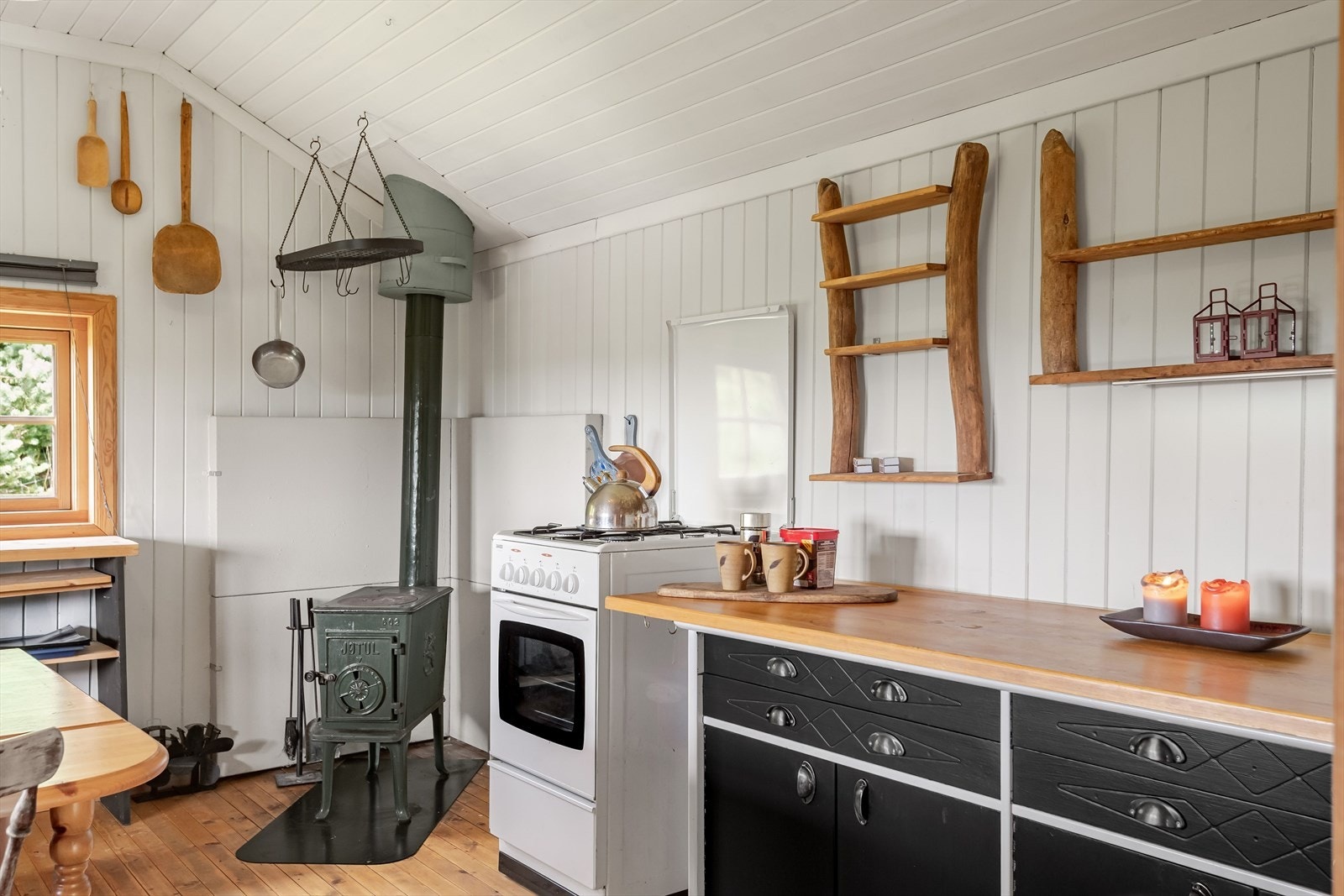 Eldre, enkel kjøkkeninnredning med heltre benkeplate, underskap og skuffer. Galleribilde