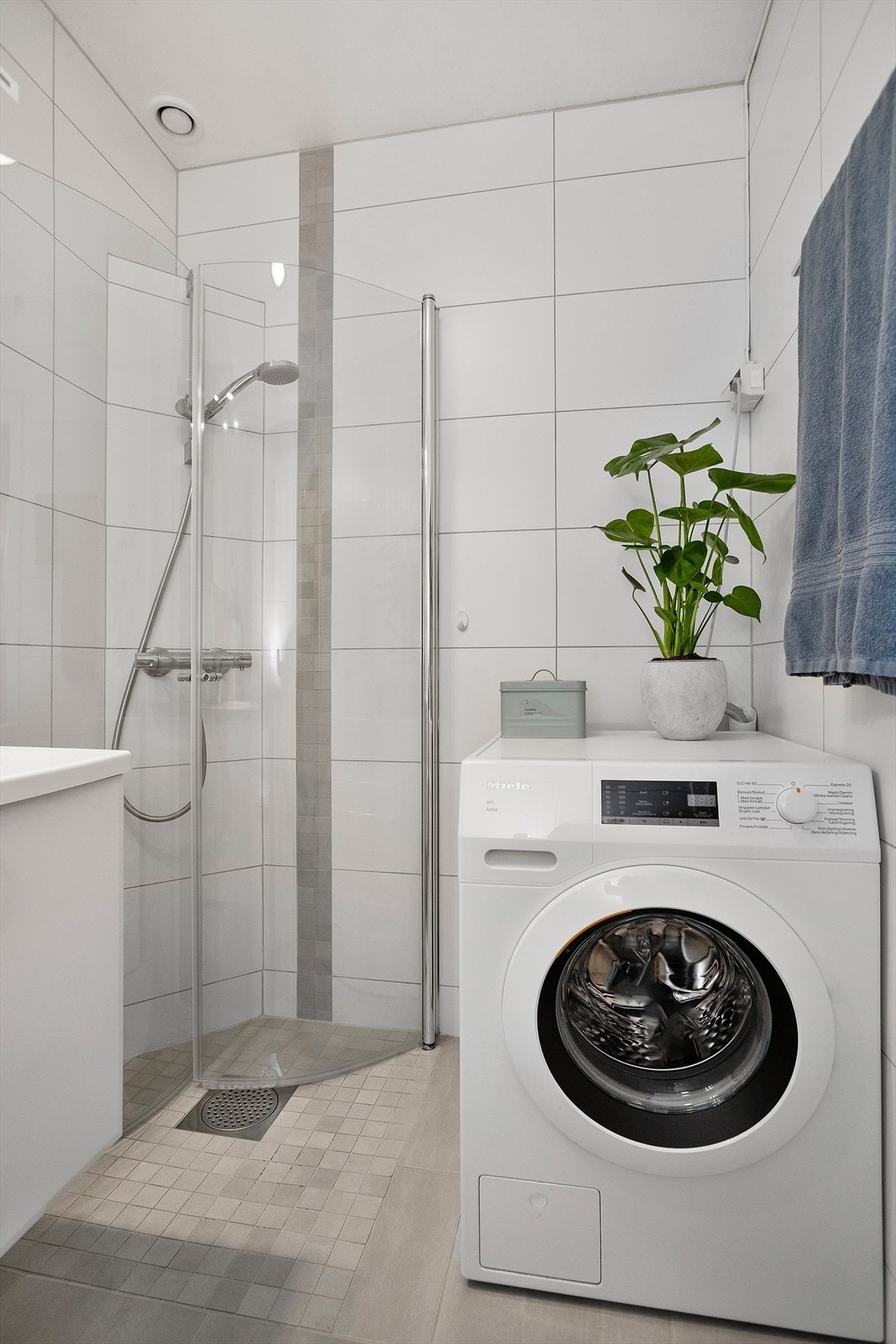 Badet har opplegg for vaskemaskin og en praktisk dusjnisje med buede glassdører. Galleribilde