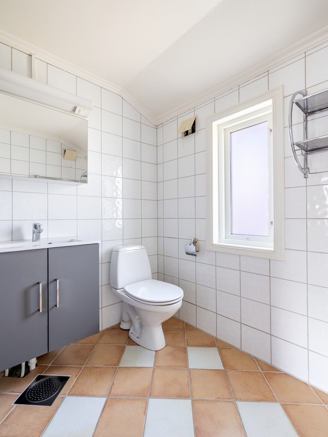 Innredningen består av nedfelt servant på skapseksjon, speil på vegg over servant, gulvstående toalett og dusjvegger/hjørne. Galleribilde