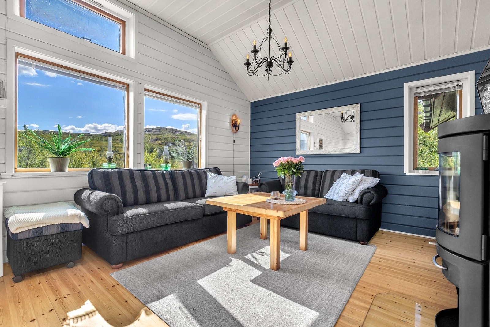 Store vindusflater gir rikelig med lys og rammer inn naturen utenfor. Galleribilde