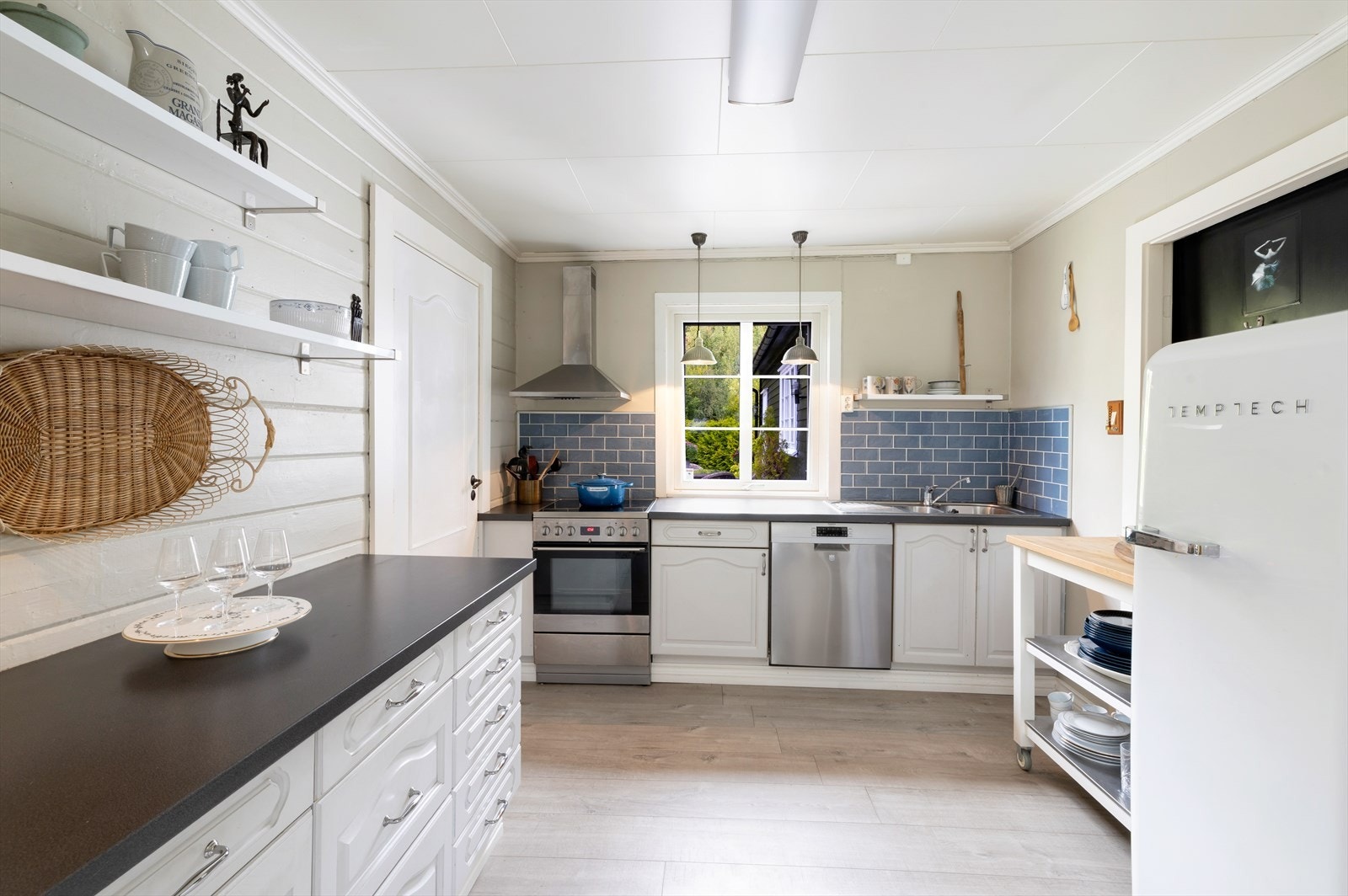 Kjøkkenet har profilerte fronter og en benkeplate av laminat, samt ventilator med avtrekk ut. Galleribilde