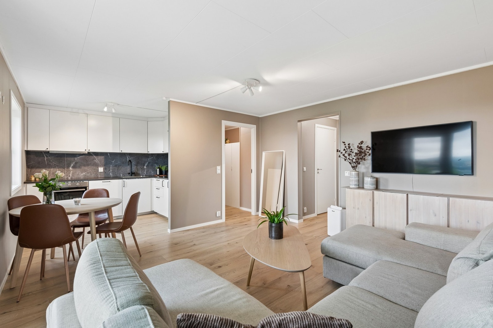 Stuen har en åpen løsning mot kjøkkenet, med plass til både sofagruppe og spisebord. Galleribilde