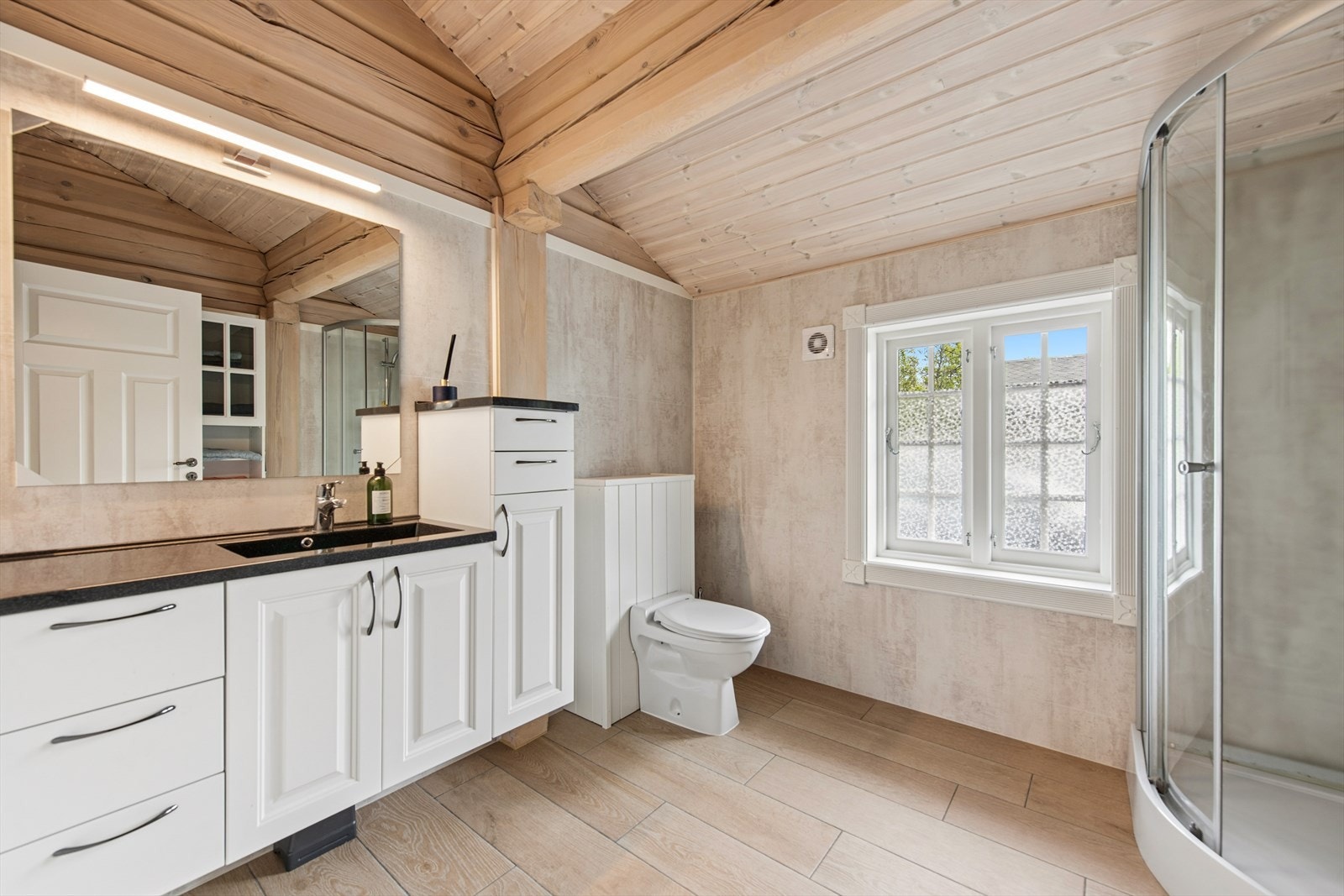 Badet har romslig innredning med nedfelt servant. Galleribilde