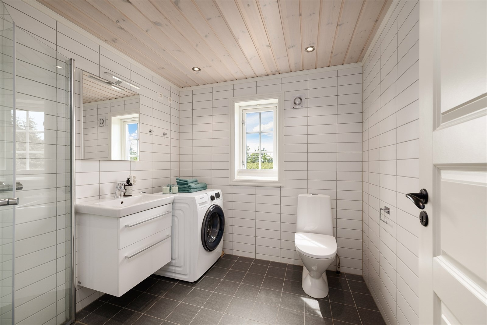 Det andre badet er også flislagt, har servantinnredning, toalett, dusj og opplegg for vaskemaskin. Galleribilde