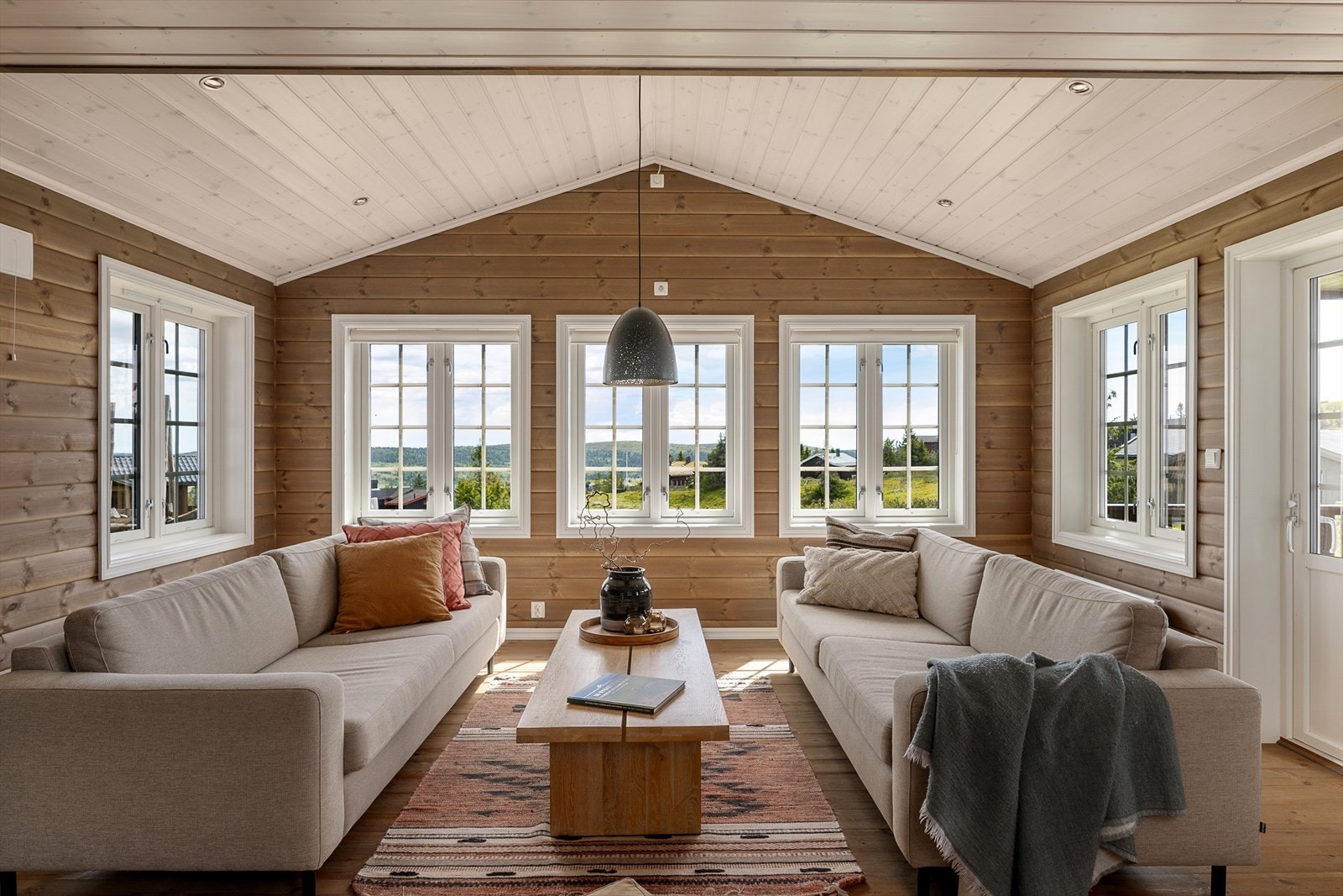 Innvendig har oppholdsrommet store vindusflater som slipper inn rikelig med naturlig lys og gir flott utsikt mot omgivelsene. Galleribilde
