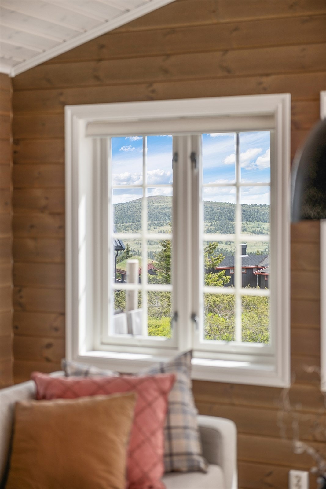Utsikt mot det omkringliggende fjellandskapet fra stuevinduet. Galleribilde