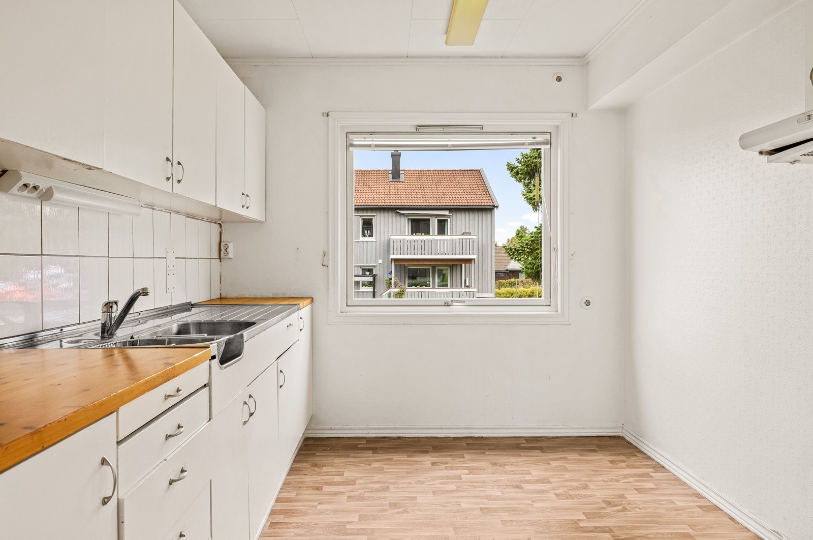 Kjøkkenet har en eldre innredning med benkeplate i tre og plass til en liten spiseplass. Galleribilde