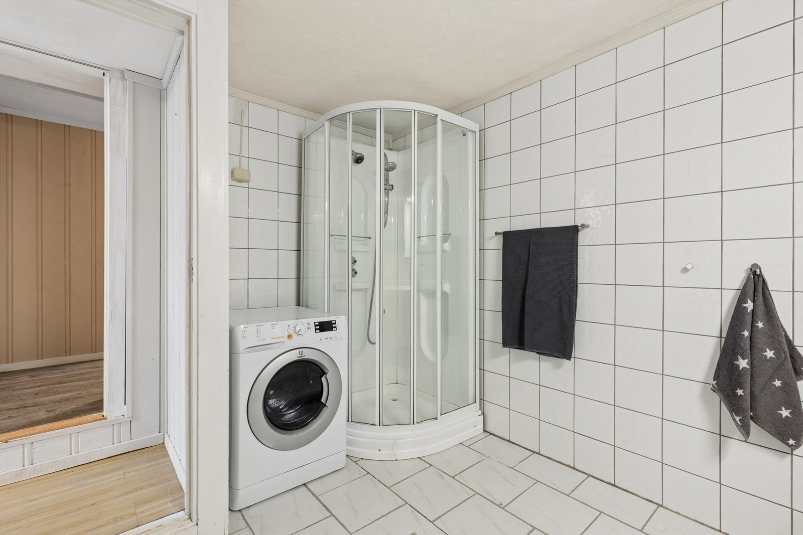 Flislagt bad med dusjkabinett og opplegg for vaskemaskin. Galleribilde