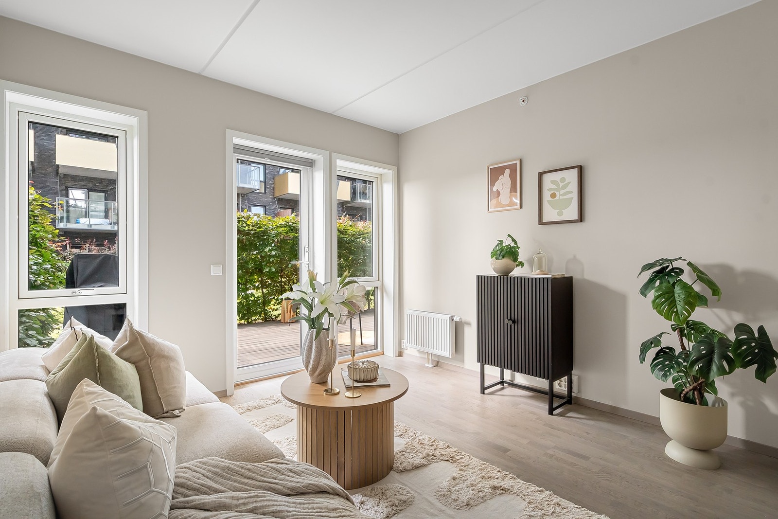 Lys og romslig stue med store vindusflater og hyggelig utsyn mot den frodige terrassen. Galleribilde