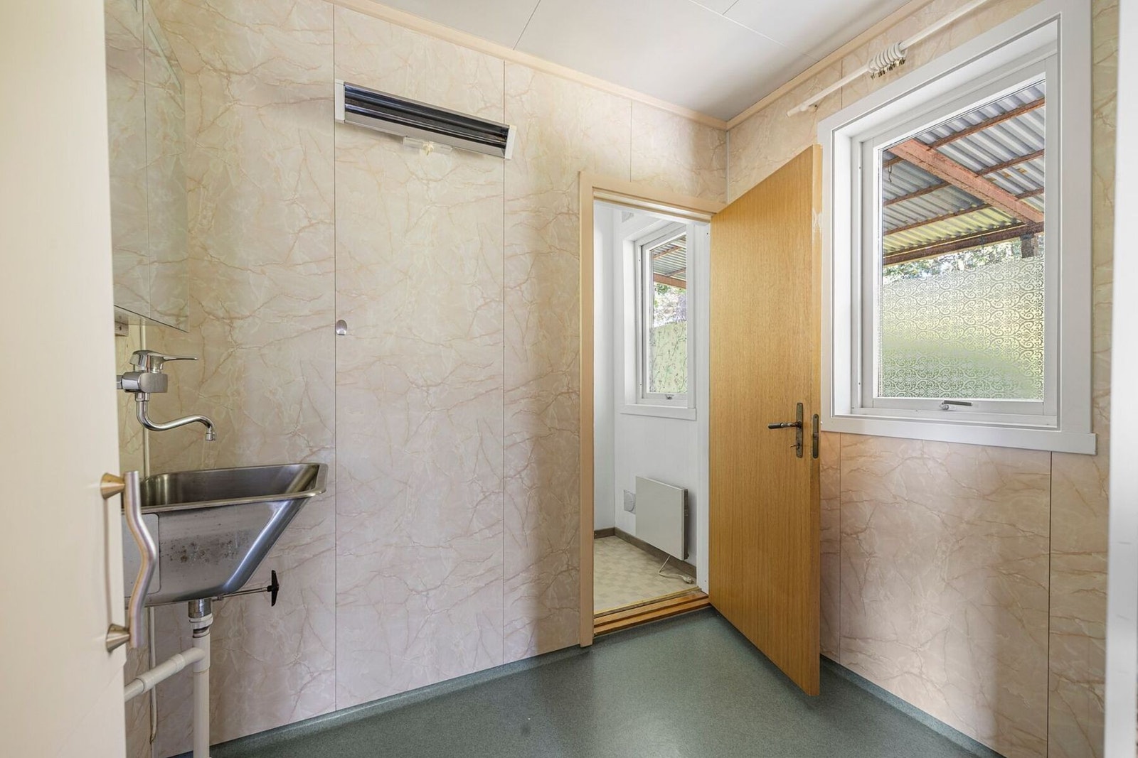 Praktisk kombinert bad og vaskerom. Rommet er innredet med dusjhjørne og utslagsvask, og har opplegg for vaskemaskin. Galleribilde