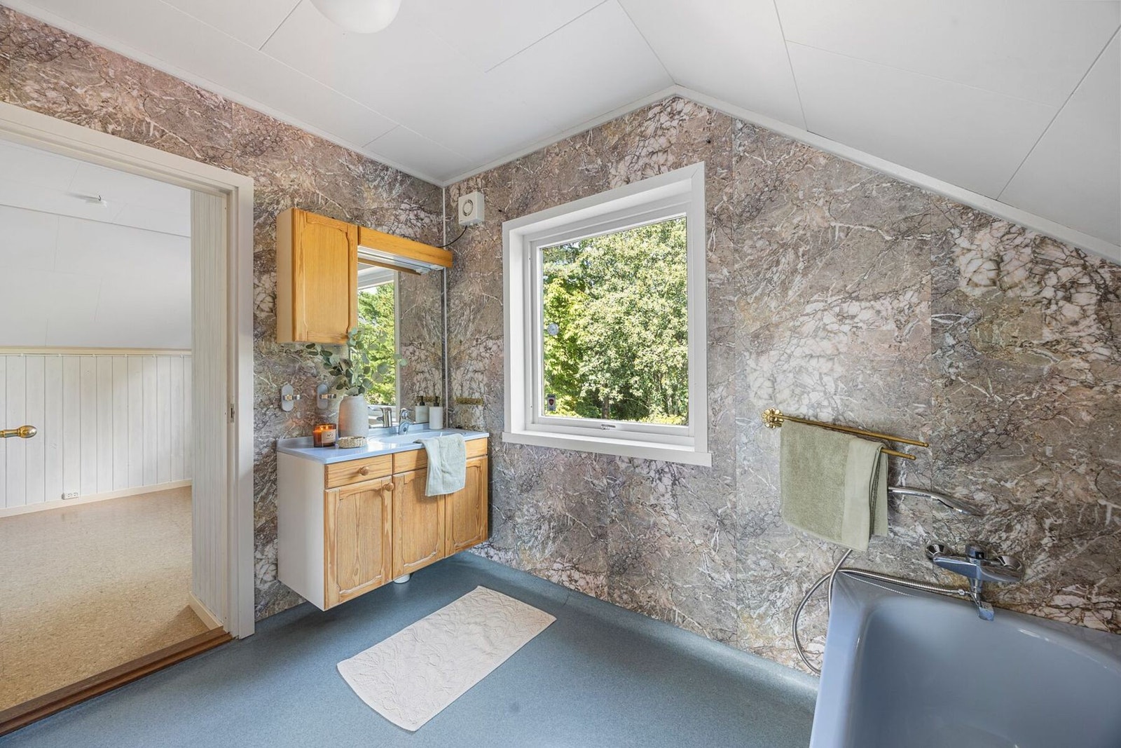 Badet i andre etasje har belegg på gulv og malte plater på vegger og i tak. Rommet er innredet med badekar og utslagsvask samt opplegg for vaskemaskin. Galleribilde