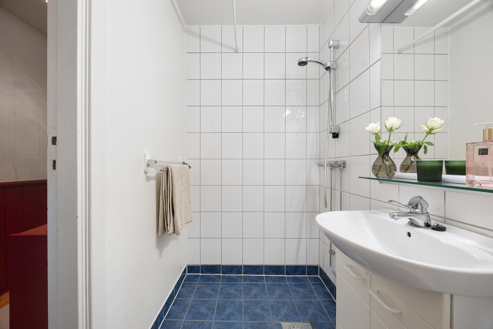 Badet er utstyrt med servant, dusj på vegg og har varm i gulv Galleribilde