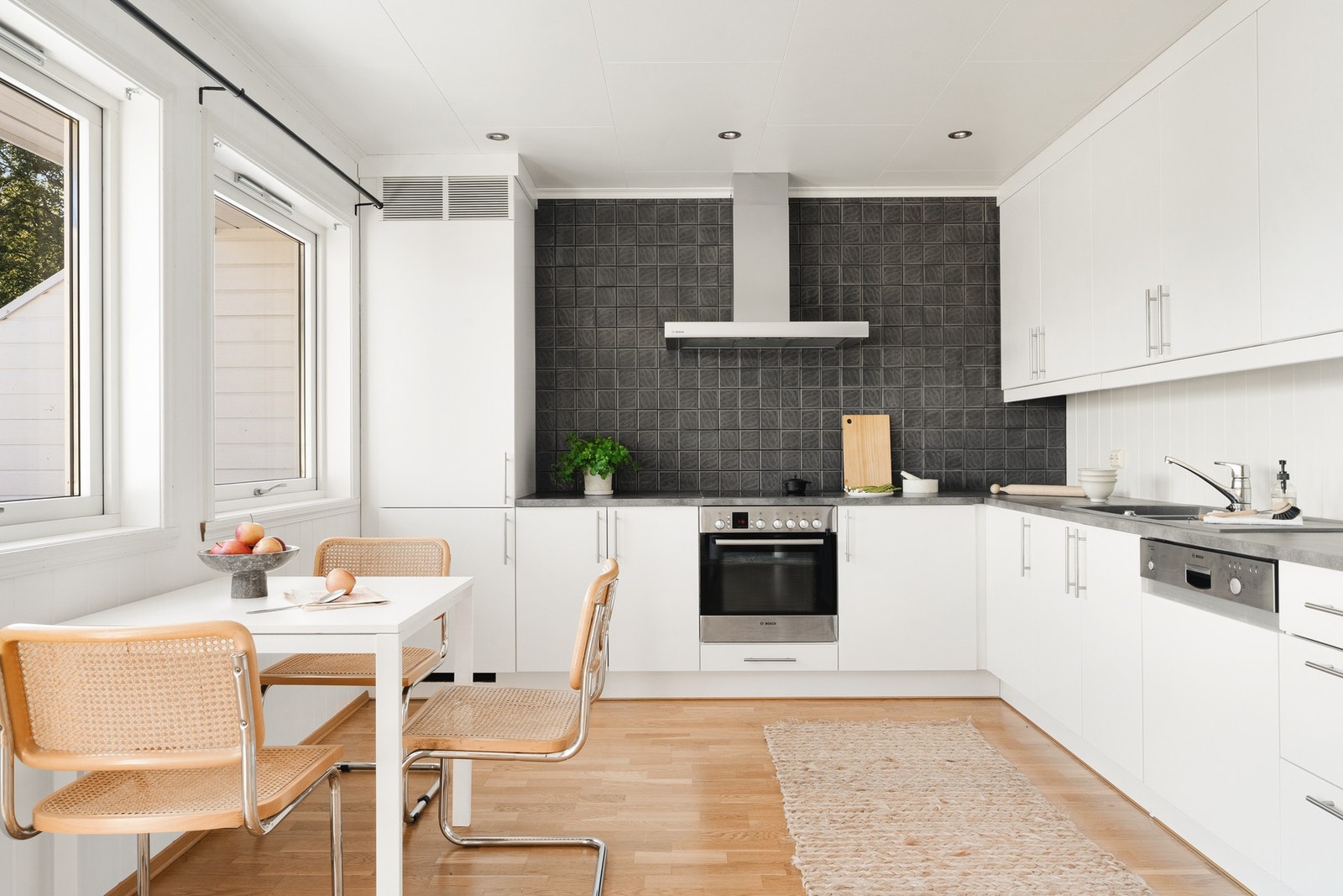 Et kjøkken med kjøleskap med fryseskap, oppvaskmaskin, platetopp, stekeovn og ventilator. Galleribilde
