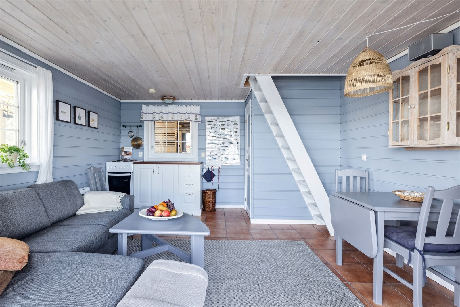 Sjøboden er innredet med sofa, spisebord og kjøkkenkrok. Galleribilde