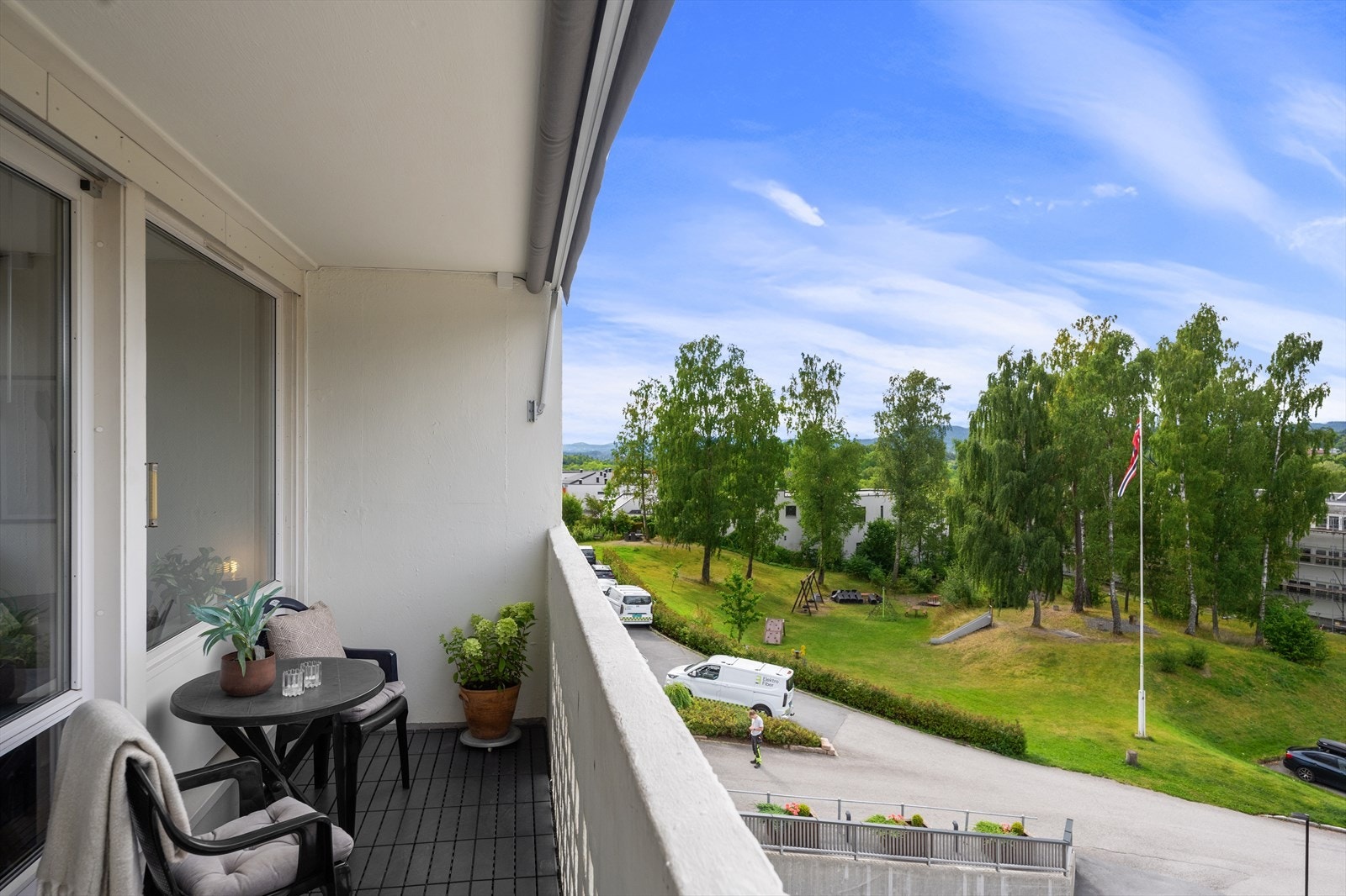 Balkongen byr på utsikt mot deler av fellesområdene og en av lekeplassene på området. Galleribilde