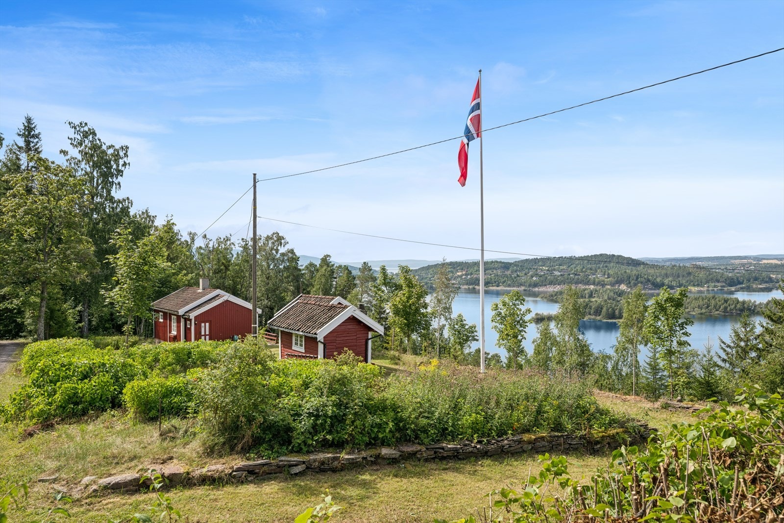 De små, røde bygningene ligger spredt på den store tomten. Galleribilde