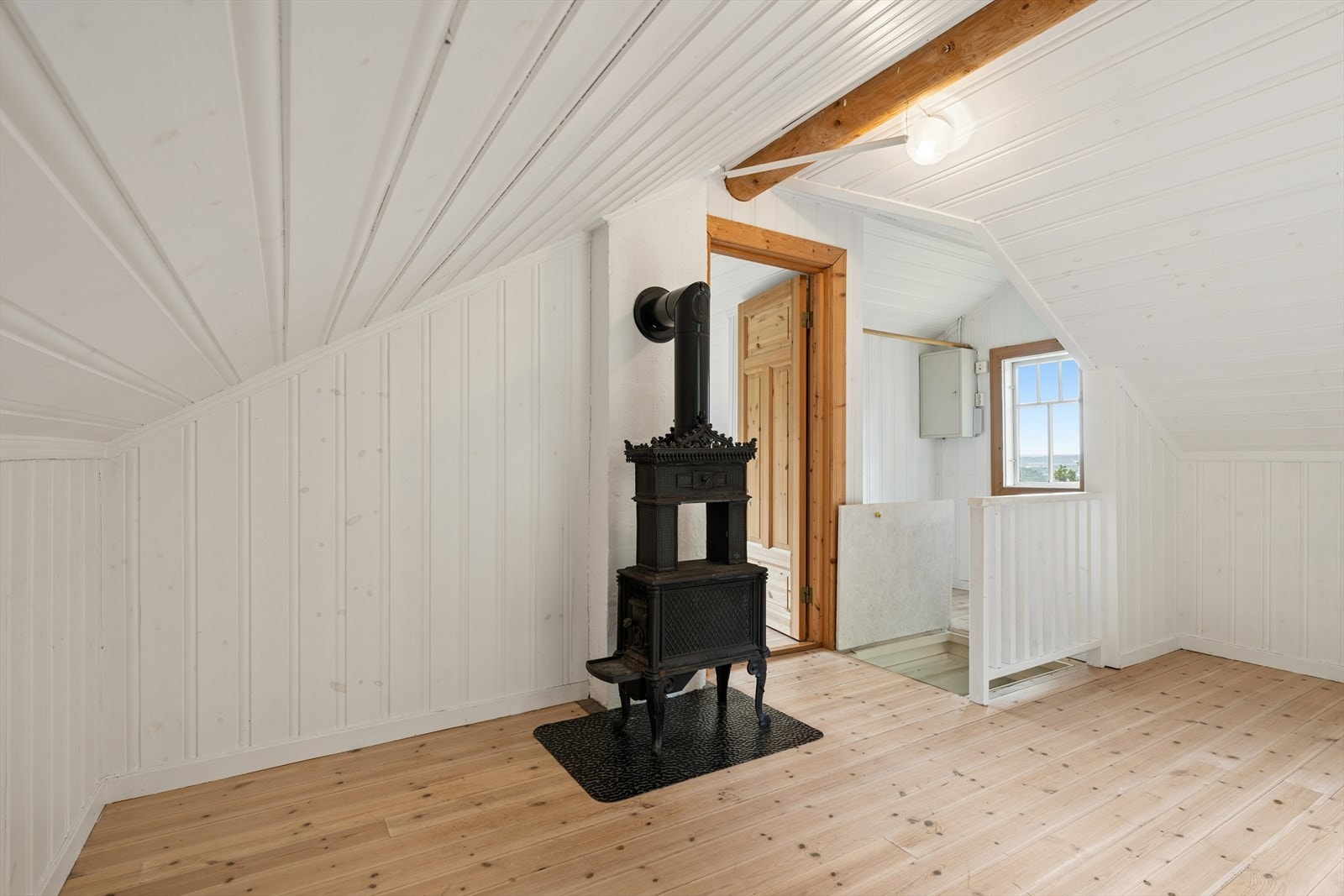Loftstuen i 'Øvre Lyse' har trepanel på vegger og tak. Galleribilde