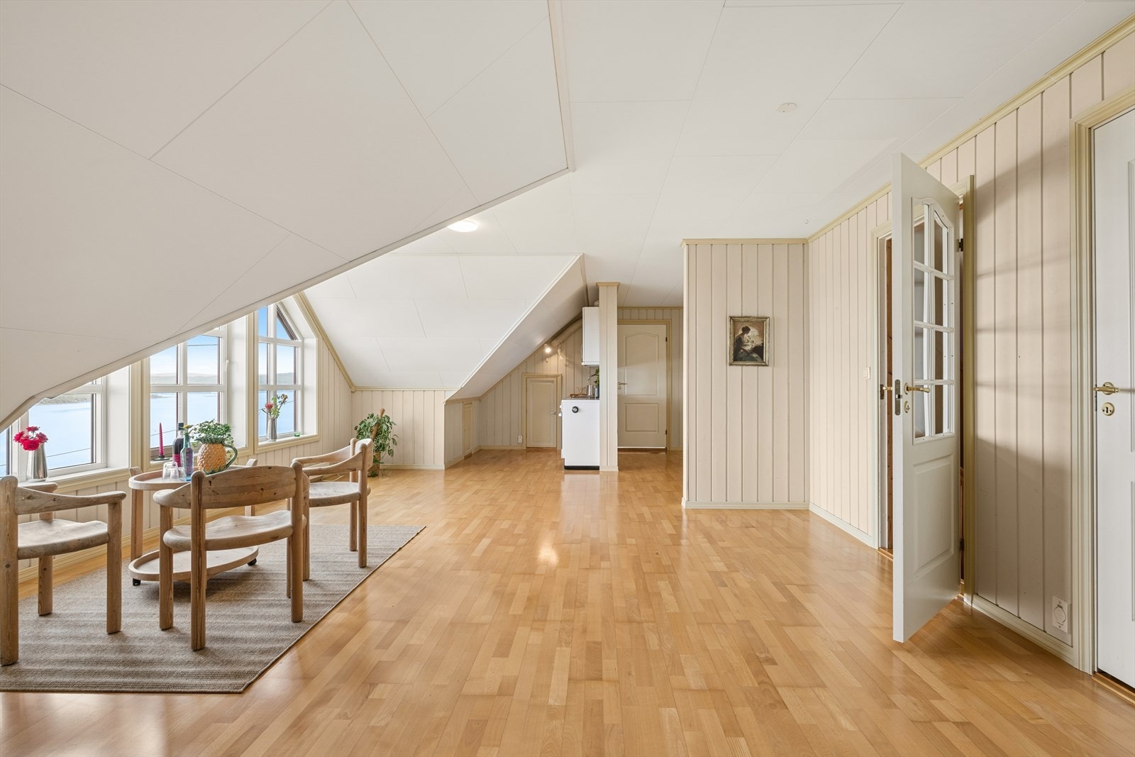 Loftsetasjen er et stort, åpent rom med parkettgulv og skråtak. Galleribilde